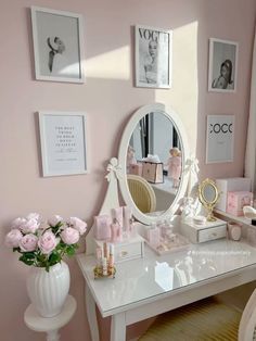 a white desk topped with a mirror and lots of pink flowers