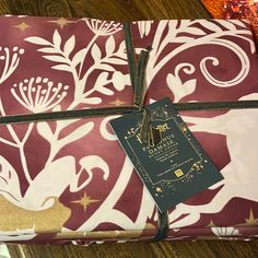 the wrapping paper is wrapped in brown and white floral designs with a gold star tag on it