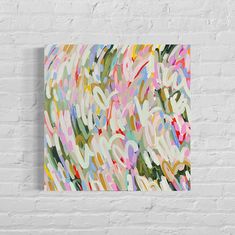 an abstract painting on a white brick wall