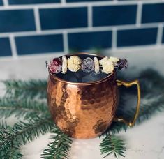 a copper mug filled with fruit and veggies on top of a white counter