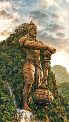 the statue is standing in front of a waterfall