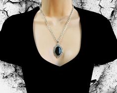 This gorgeous necklace is made with a Black Onyx gemstone set in a filigree bezel. It is a large pendant measuring about 1.25 inches wide and 2 inches long.  The onyx gemstone is pure black and the cabochon is thick. The chain is very sturdy and your favorite length will be custom made for you. All metal is silver plated.   Onyx is best known for protection, healing, harmony, stamina, self-confidence, success and responsibility. Cool, huh? Ships in an organza gift bag. More to see at: ArtisticDe Gothic Onyx Jewelry For Gift, Black Metal Necklace With Locket, Gothic Onyx Necklace As A Gift, Gothic Onyx Necklace Gift, Black Gothic Cabochon Jewelry, Gothic Black Cabochon Jewelry, Onyx Jewelry With Large Pendant As Gift, Black Oval Jewelry With Large Pendant, Onyx Large Pendant Jewelry As Gift