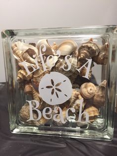 there is a glass block with shells in it and the words life's a beach