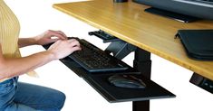 a person sitting at a desk using a keyboard and mouse