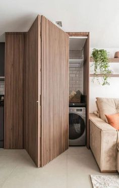 a living room filled with furniture and a washer dryer next to a kitchen