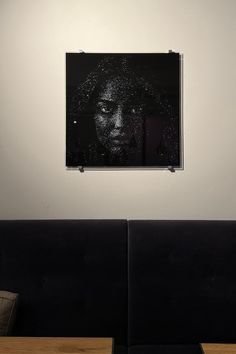 a black and white photo hanging on the wall above two booth seats in a restaurant