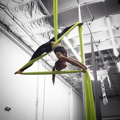 a woman is doing aerial tricks on a pole