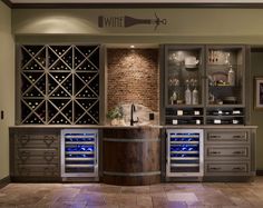 a wine cellar with many bottles and glasses on the shelves, next to a counter