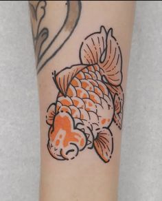 a fish tattoo on the arm with an orange and black outline in front of it