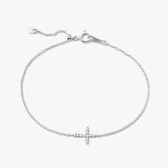 Our Esther Dainty Diamond Cross Bracelet is a glimmering beacon of faith. Stylish and elegant, this bracelet embodies the beauty of His grace. Perfect to shine on its own but sophisticated enough to add to a stack. The intentional delicacy of this design makes for the heartfelt gift of a child's first piece of fine jewelry or an adult's everyday dainty wear. Metal: 18k White Gold / 18k Yellow Gold / 18k Rose Gold Round Brilliant Cut Natural Diamonds: Approx. 0.10 ctw G Color and SI1-2 Clarity Diamonds Length: 7 inches at the longest. ﻿Adjustable sliding bead to provide options for smaller wrist size. Closure: Lobster clasp Measurements: Approx. 11.7mm length x 5.9mm width Looking for a different size? Please email us. Elegant Sterling Silver Cross Rosary Bracelet, Elegant Adjustable Cross Bracelet, Elegant Sterling Silver White Gold Rosary Bracelet, Elegant Sterling Silver Rosary Bracelet, Elegant Sterling Silver Round Rosary Bracelet, Collar Chain, Mens Engagement, Diamond Cross, Bridal Bands