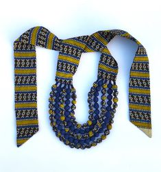 a blue, yellow and white tie with beads on it's end is shown