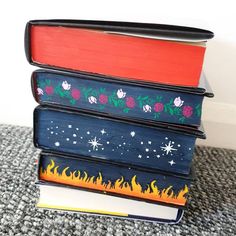 a stack of books sitting on top of a carpeted floor next to a wall