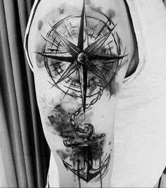 a black and white photo of a man's arm with a compass tattoo on it