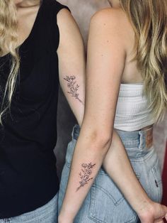 two women with matching tattoos on their arms