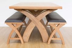 a wooden table with two black leather chairs