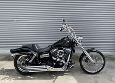 a black motorcycle parked in front of a garage door