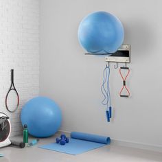 there is a gym room with exercise equipment on the wall