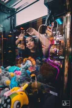 a woman looking at stuffed animals in a store window