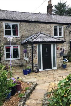 a stone house with a basketball hoop in the front yard