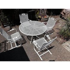 an outdoor table and chairs are sitting on the ground