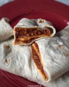 two burritos are sitting on a red plate