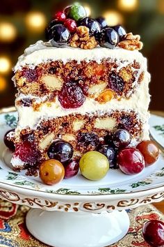 a piece of cake on a plate with grapes and walnuts