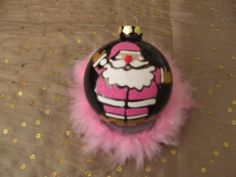 a pink and black ornament sitting on top of a bed