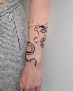 a woman's arm with a tattoo on it and a snake in the middle