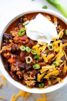 a white bowl filled with chili and cheese