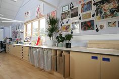 a room filled with lots of books and pictures on the wall next to a window