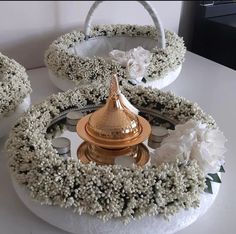 a white table topped with lots of flowers and a gold cup on top of it