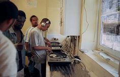 three men standing in front of a sink with headphones on