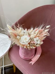 a pink chair with flowers and feathers on it