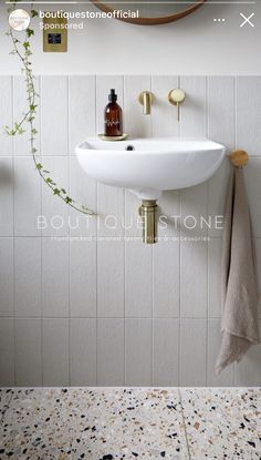 a white sink sitting under a mirror next to a wall mounted faucet in a bathroom