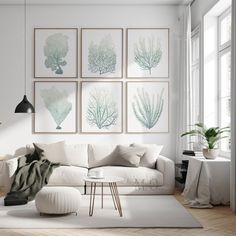 a living room filled with white furniture and paintings on the wall above it's windows