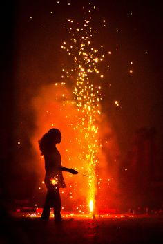 a person standing in front of a firework display