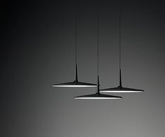 three lights hanging from the ceiling in a dark room