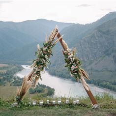 an outdoor ceremony setup with flowers and pamodia in the foreground, overlooking a river