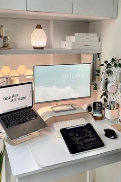 a desk with a laptop, monitor and keyboard on it