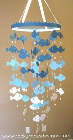 a blue and white fish mobile hanging from the ceiling in a child's room