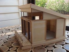 a doll house made out of wood sitting on top of a wooden table next to a window