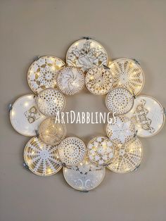 the word artdalblings is surrounded by many decorative plates and lights on a wall