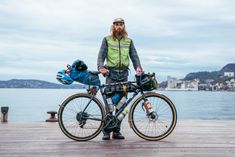 a bearded man standing next to his bike