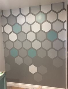 the wall is painted with hexagonal tiles in shades of gray and aqua blue