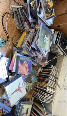 a pile of cds and dvds sitting on top of a wooden floor