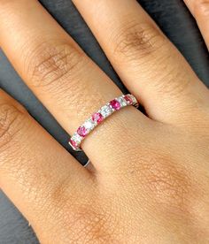 a woman's hand with a pink and white diamond ring