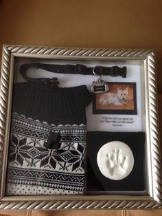 a dog's paw and sweater in a silver frame