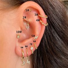 four pairs of ear piercings with different designs on each side and the number one behind them