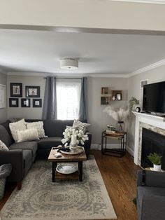 a living room filled with furniture and a flat screen tv mounted on the wall above a fire place