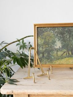 a painting is sitting on top of a table next to a pair of brass legs